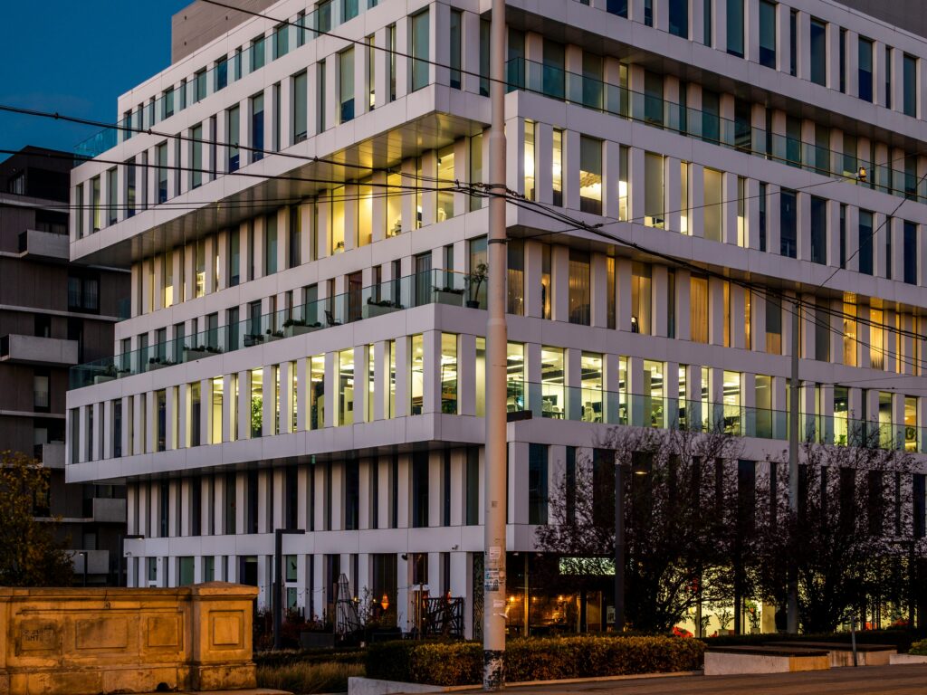 A modern office building with illuminated interior, captured at dusk.